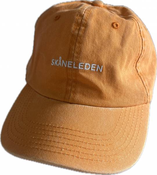Gul keps med Sk&aring;neleden i text p&aring; framsidan, logotype p&aring; baksidan